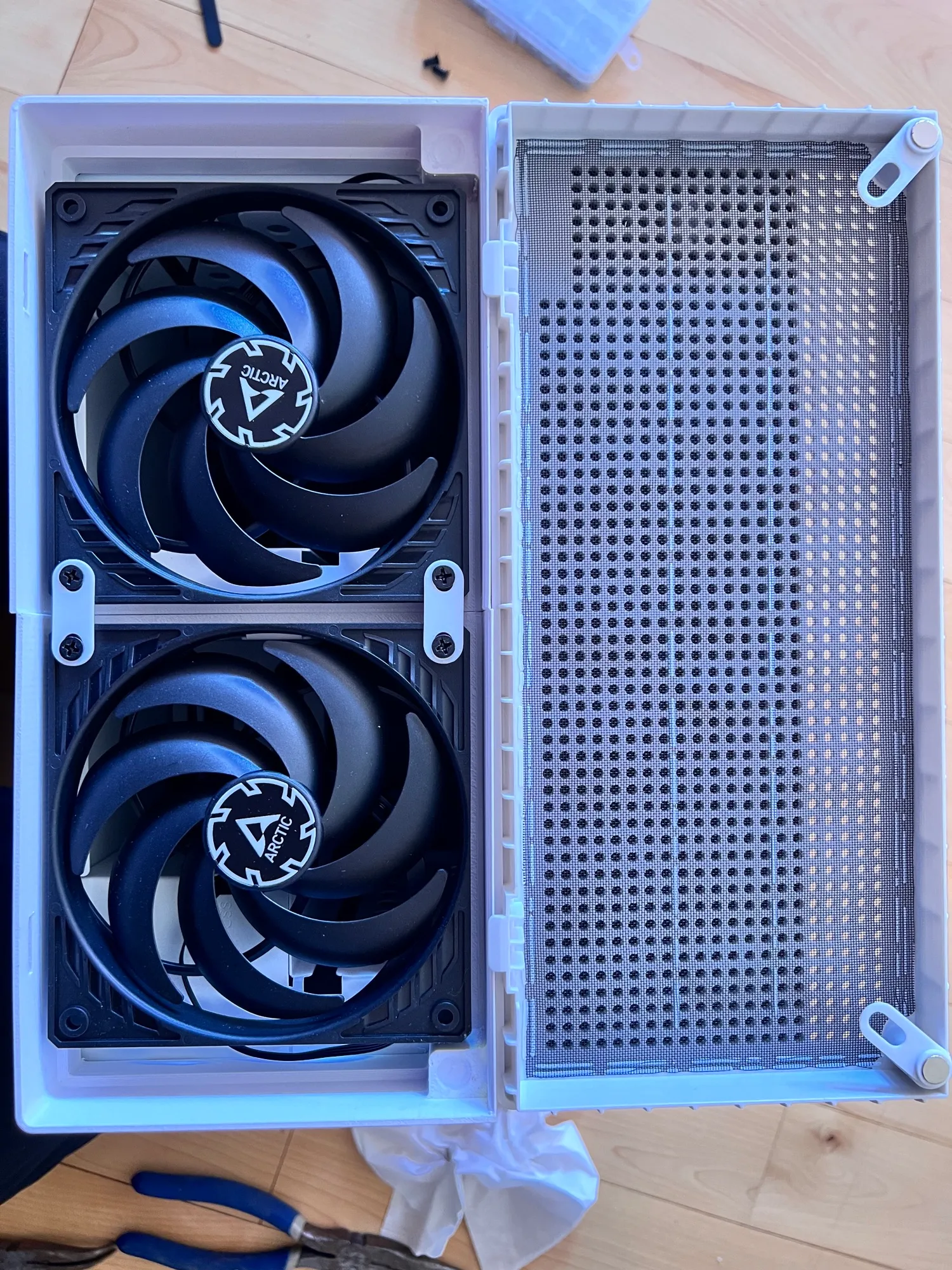 Two Arctic 140 mm fans in the printed front frame, with the magnetic mesh beside them
