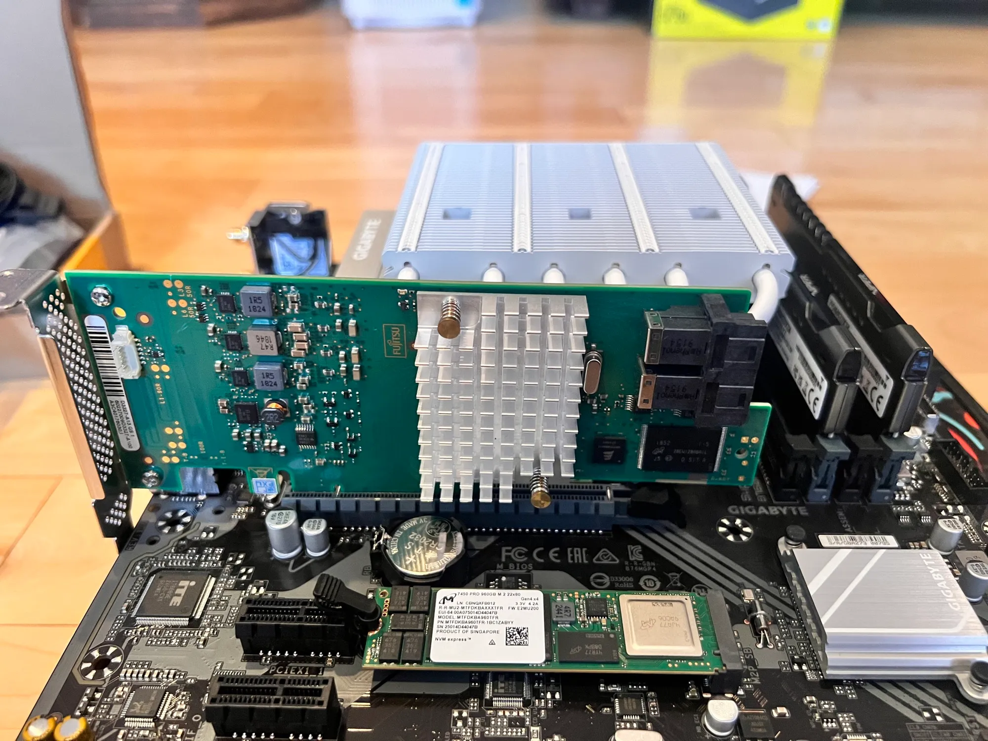 The Fujitsu 9300-8i being seated, with a Micron label visible below it
